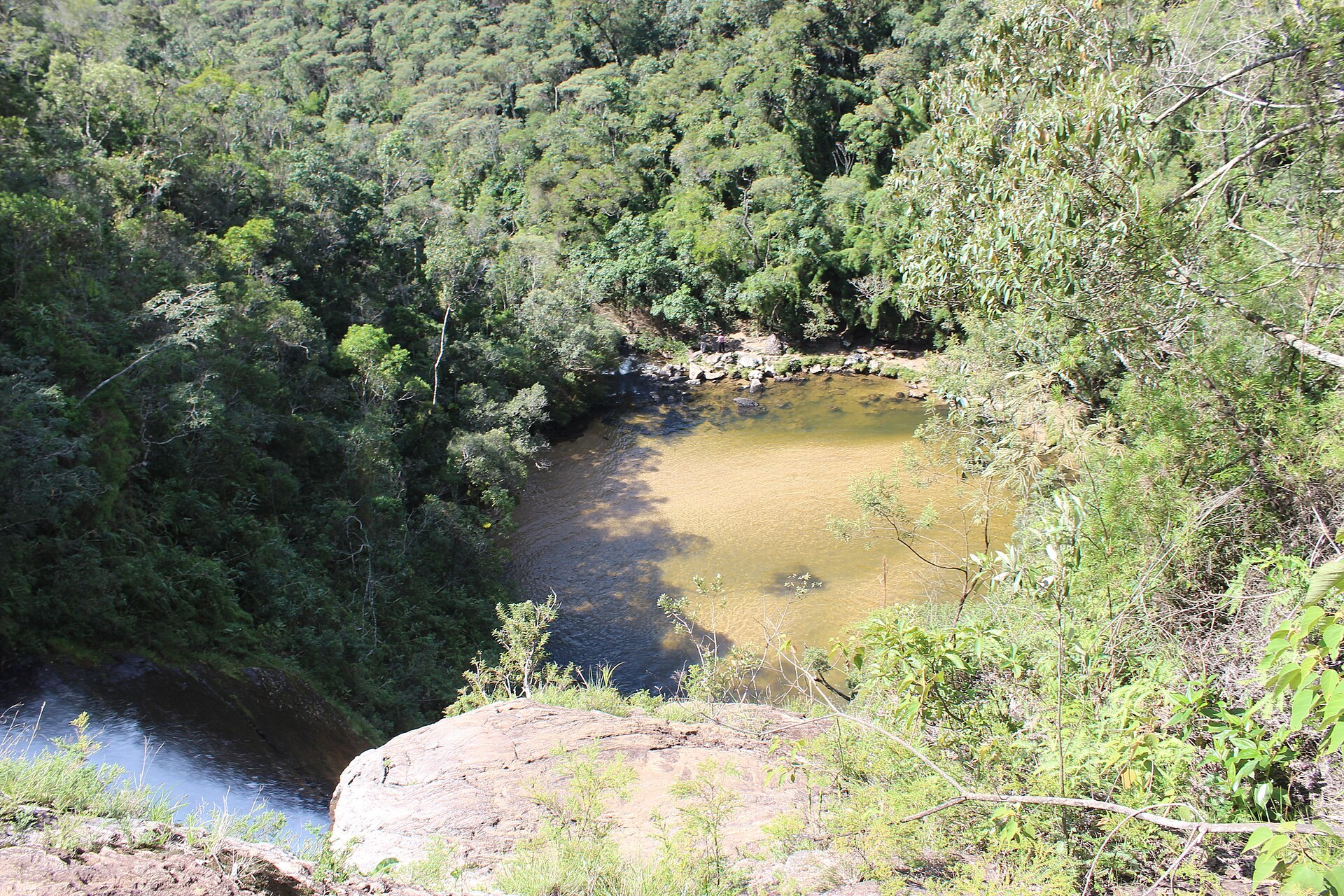 Poço de água âmbar visto de cima, cercado de Mata Atlântica no Parque Nacional da Serra da Bocaina.